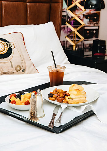 Breakfast in Bed with fruit, eggs, potatoes, and iced coffee